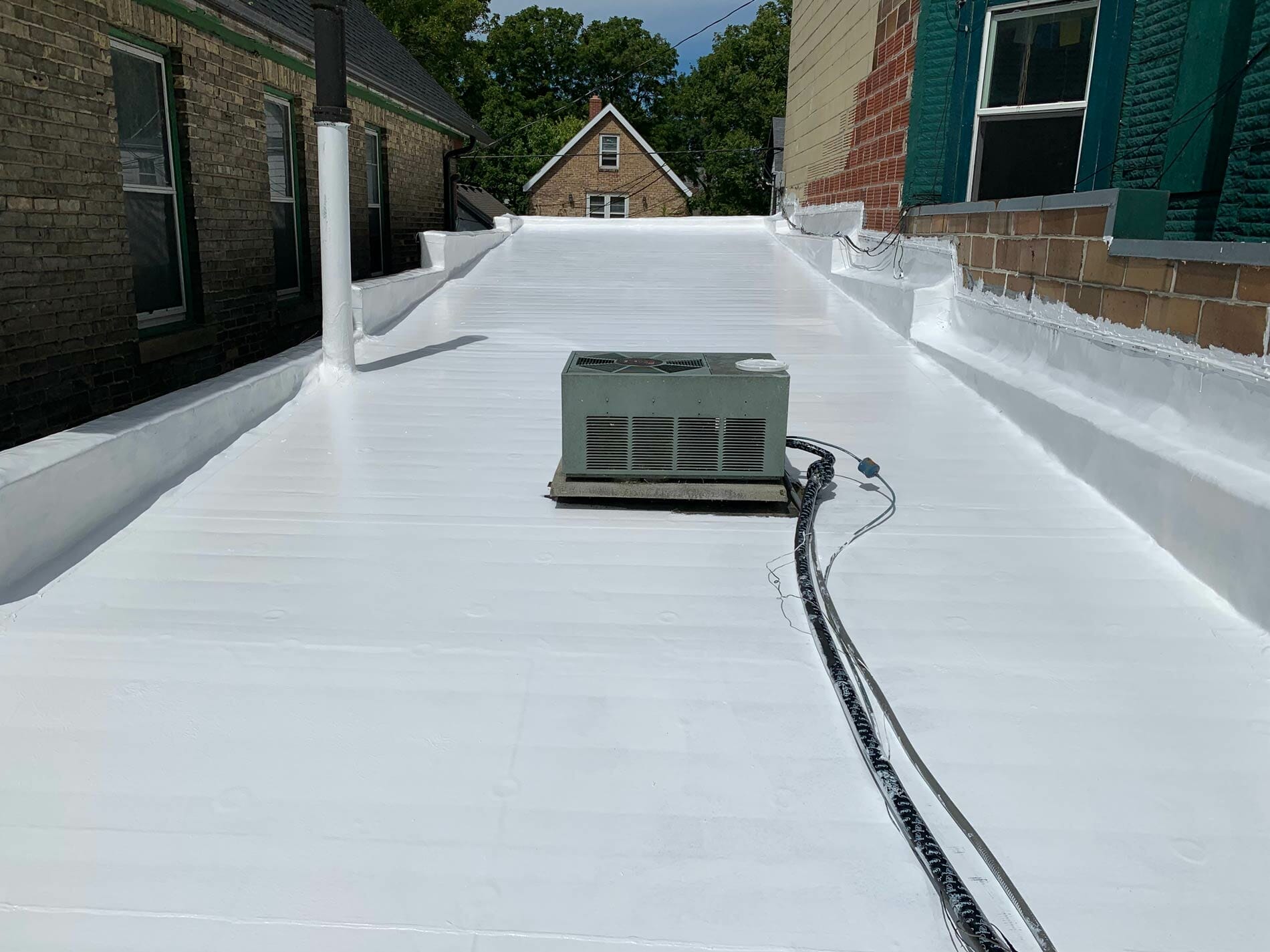 white roof coating on a residential flat roofing system